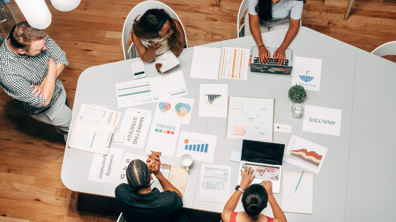 Insurance team reviewing strategy documents and charts on a conference table